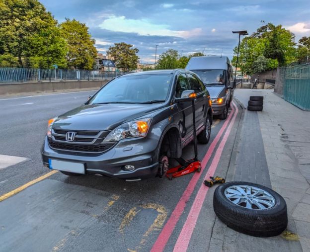 Mobile tyre fitter working on a car wheel